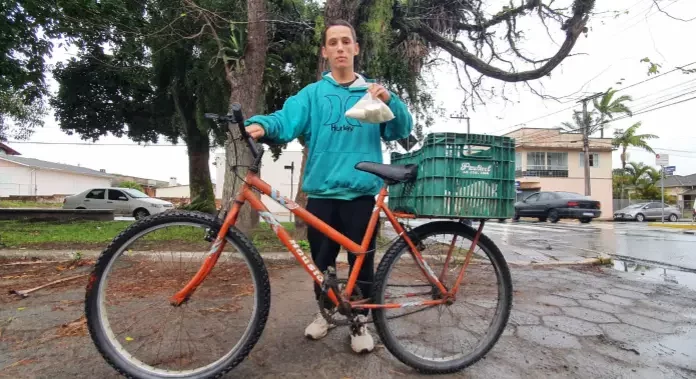Jovem enfrenta chuva e frio para ganhar a vida honestamente vendendo Aipim em Sombrio